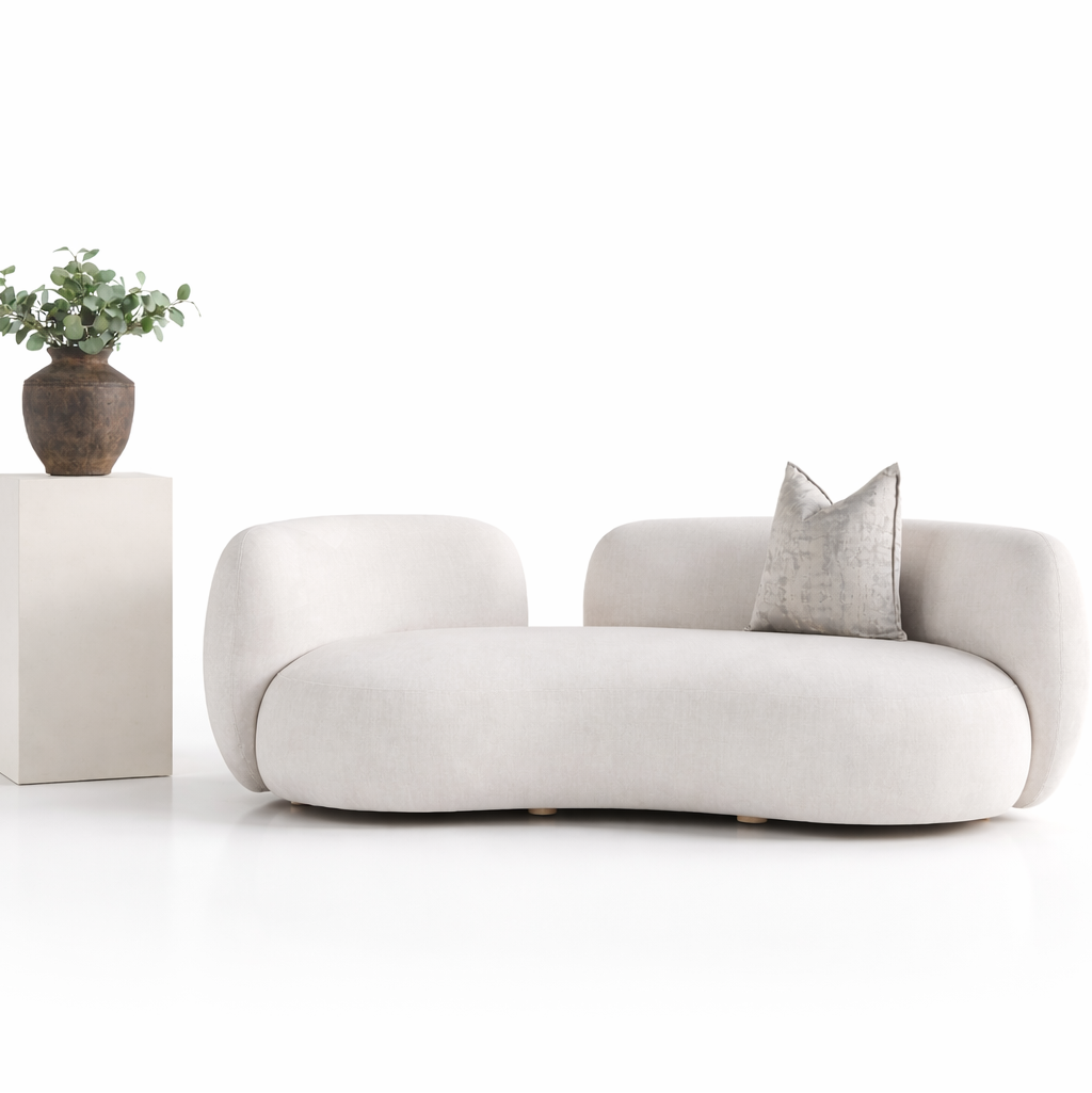 A compact cream bouclé sofa with rounded arms styled with a silver cushion and a terracotta vase with eucalyptus
