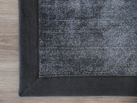 
                  
                    Handwoven charcoal border rug with two-tone loop-tip texture
                  
                